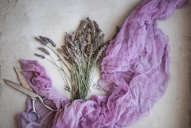 A close-up shot of lavender and rose quartz colored fabrics with different textures (silk, linen, chiffon) draped artistically. The fabrics are subtly lit to highlight their delicate hues and textures, creating a soft and luxurious feel.