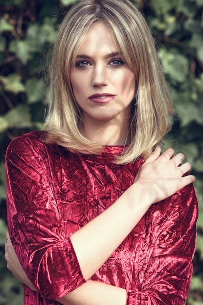 A Woman presenting square face shape hairstyle with layered long bob and side swept bangs.