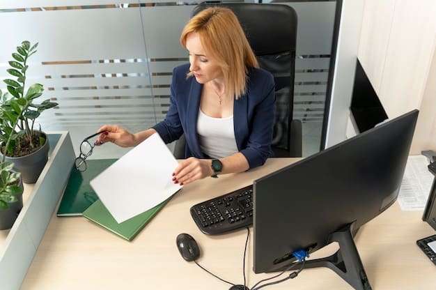 A person sitting at a desk, reviewing documents related to rental assistance programs, with a laptop showing application forms.