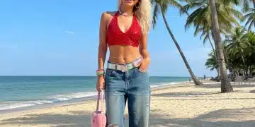 Jovem estilosa com look Y2K repaginado em praia brasileira, celebrando as tendências de verão 2026.